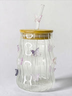 Tagerelsa3ada clear glass tumbler with wavy texture and purple butterfly embellishments, bamboo lid, and glass straw.