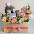 Tagerelsa3ada Chef Penguin Flower Arrangement with pink and white daisies in a cream box with pink ribbon.