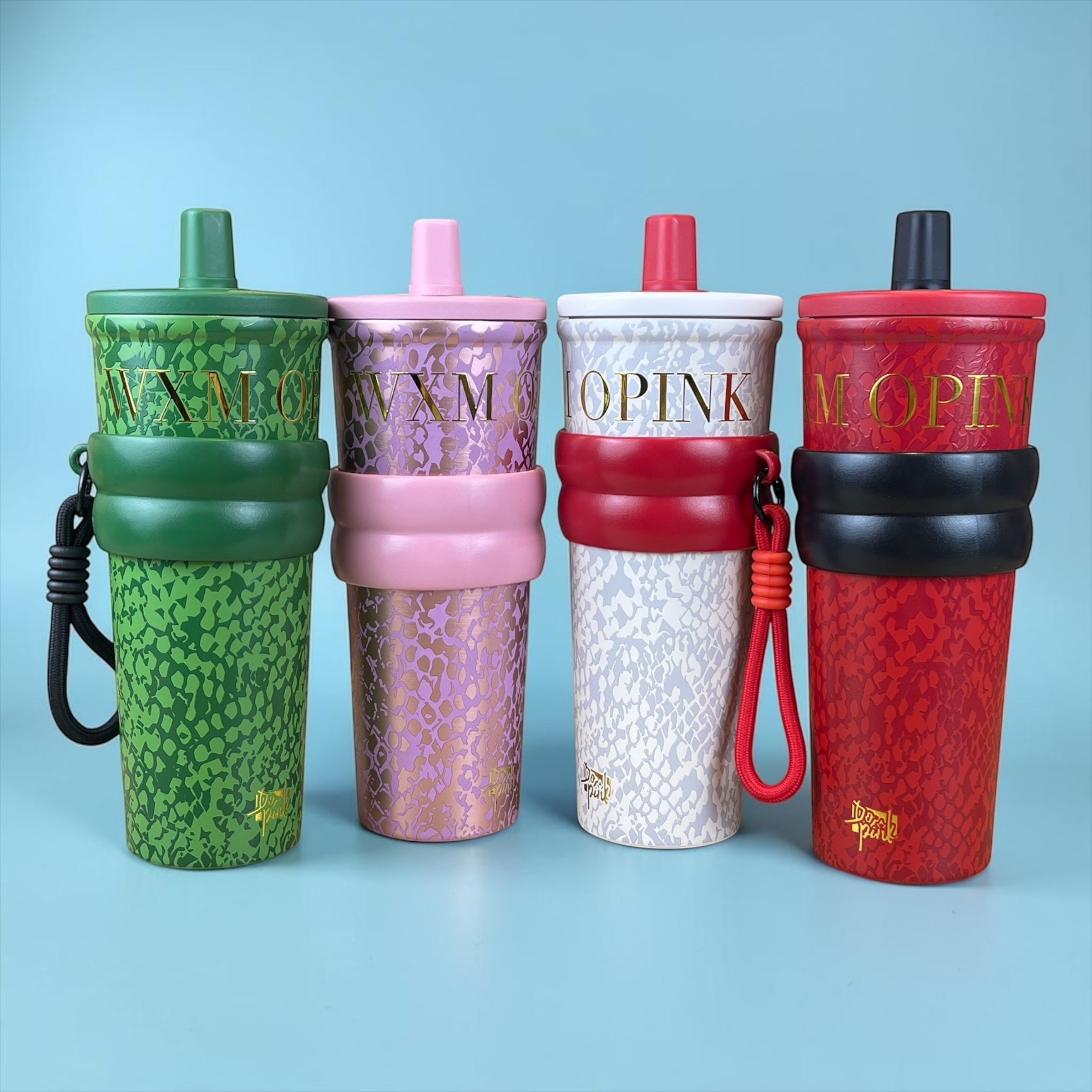 Tagerelsa3ada designer tumblers with straps in green, pink, white, and red, featuring snakeskin pattern and gold lettering.