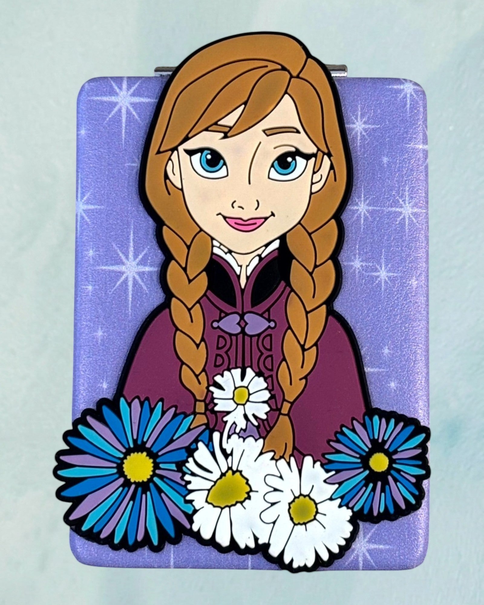 Tagerelsa3ada Disney Frozen Anna compact mirror with purple glitter background and floral accents.