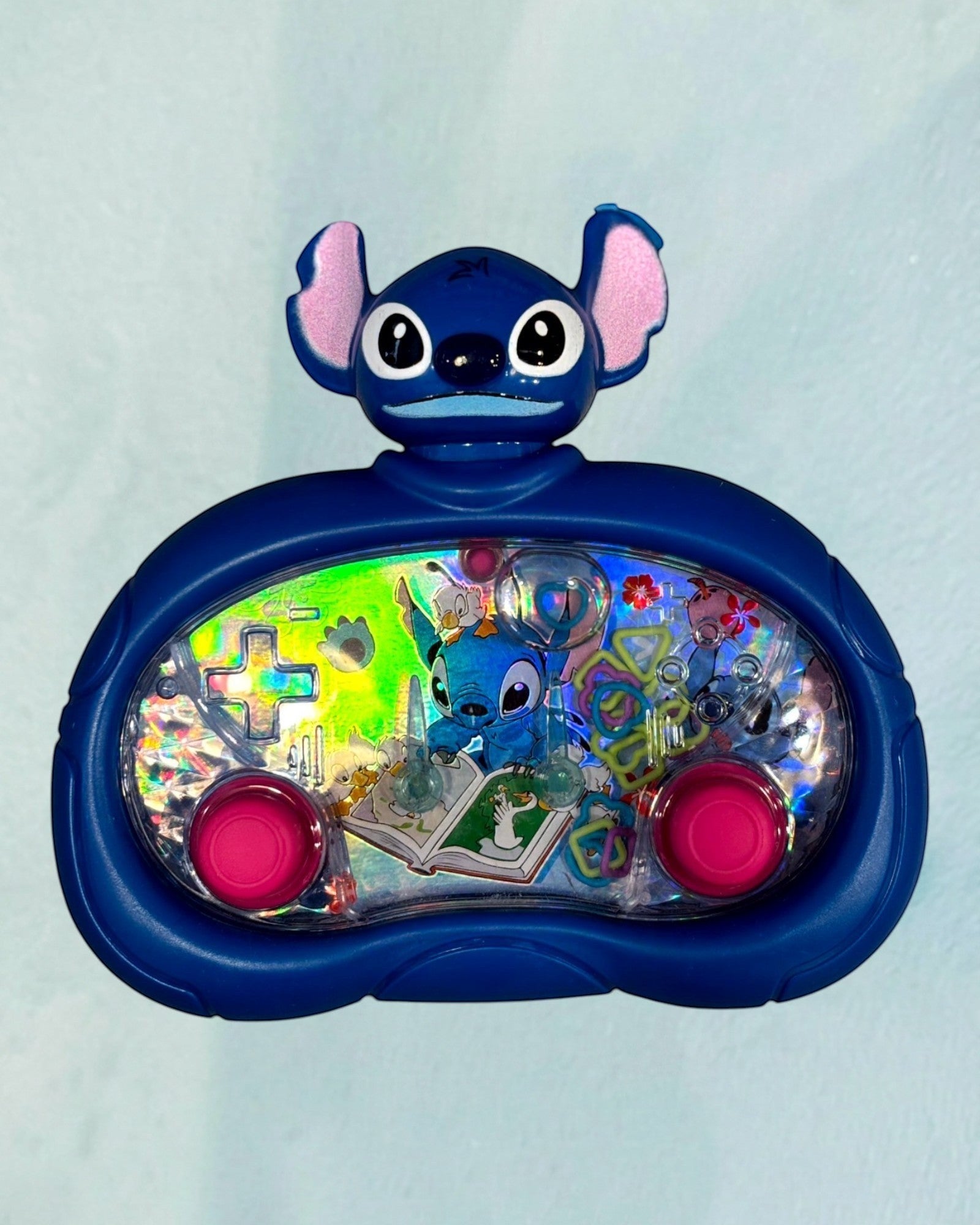Tagerelsa3ada blue Disney Stitch water game with pink buttons and floating rings. Features Stitch character on a book.