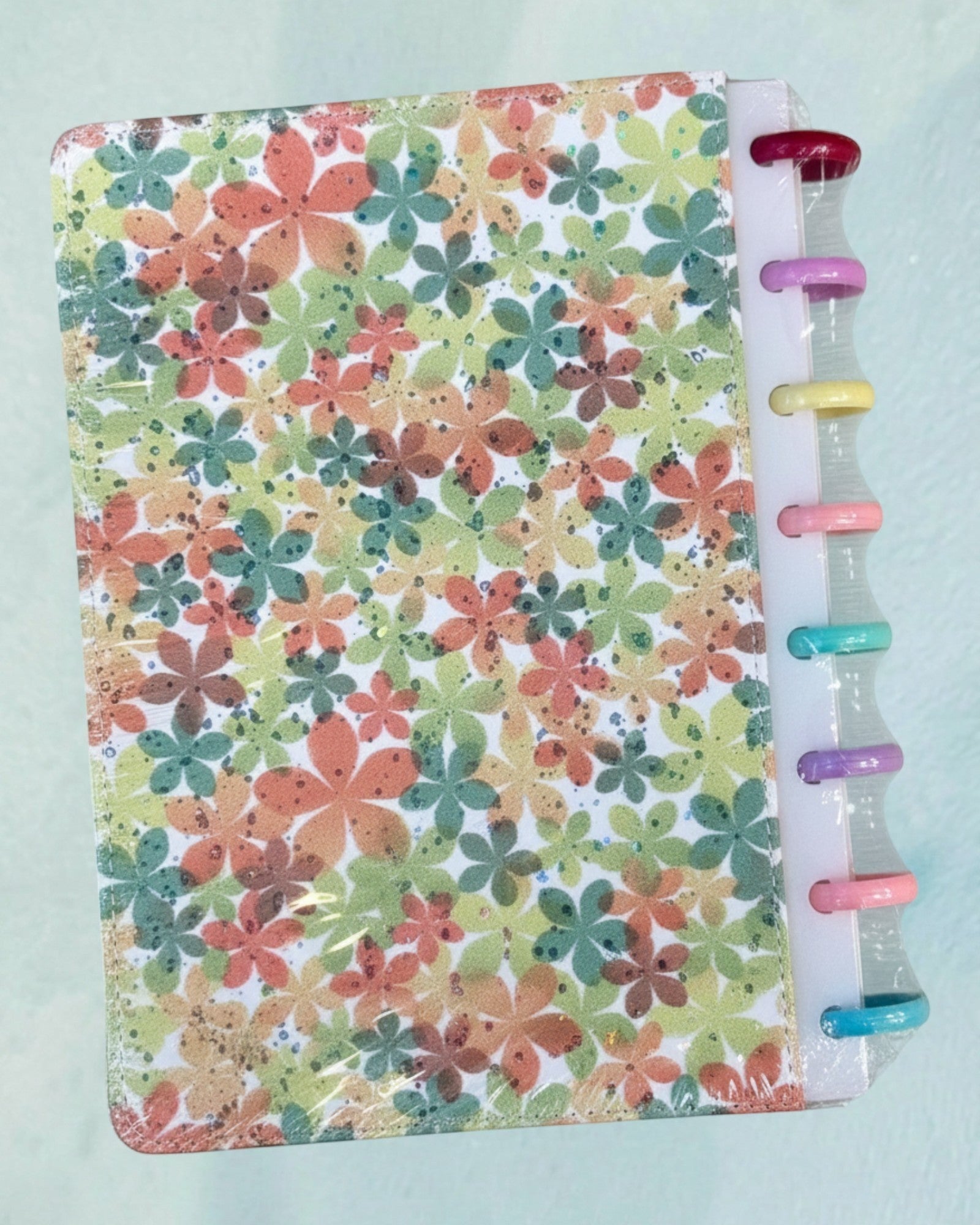 Tagerelsa3ada floral discbound planner with colorful flower print and pastel disc binding.