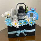 Tagerelsa3ada grey plush bunny, blue and white daisies, grey water bottle, and blue toy in a black gift box with a light blue ribbon.