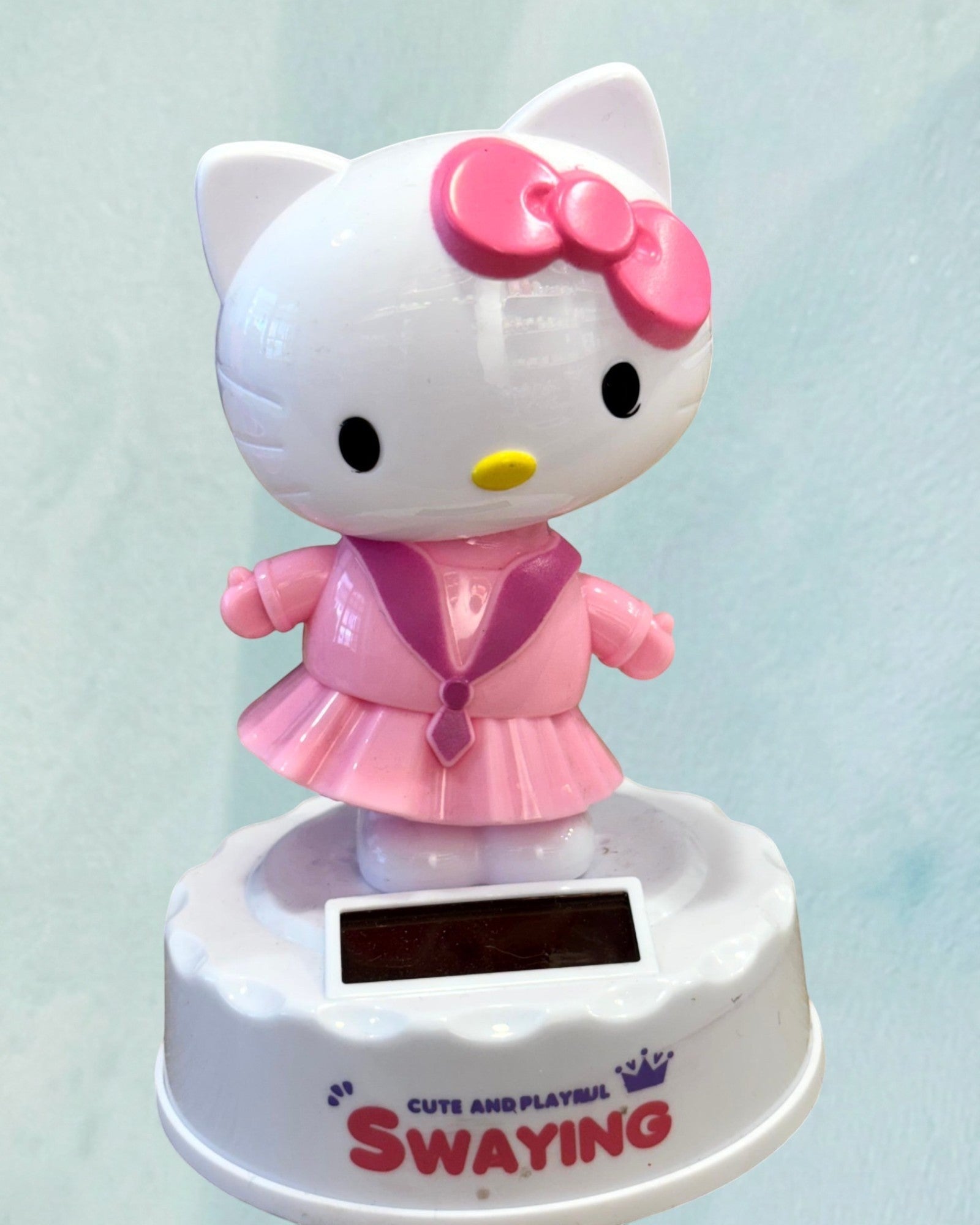 Tagerelsa3ada white and pink Hello Kitty solar-powered dancing figurine wearing a pink dress and bow.