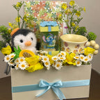 Tagerelsa3ada Penguin and Stitch gift box with yellow roses, daisies, plush penguin, Stitch figurine, and mug.