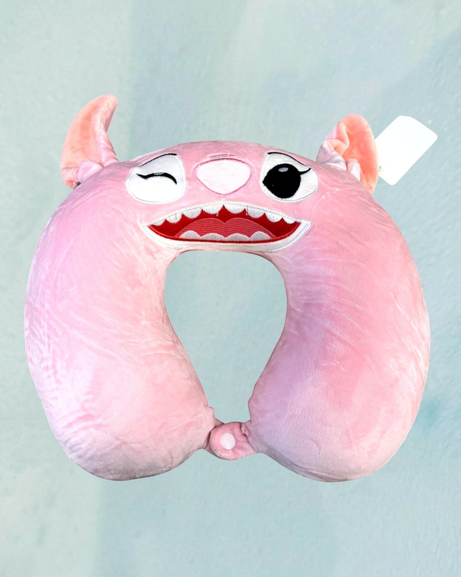 Tagerelsa3ada pink plush character travel neck pillow with embroidered face and ears, perfect for comfortable journeys.