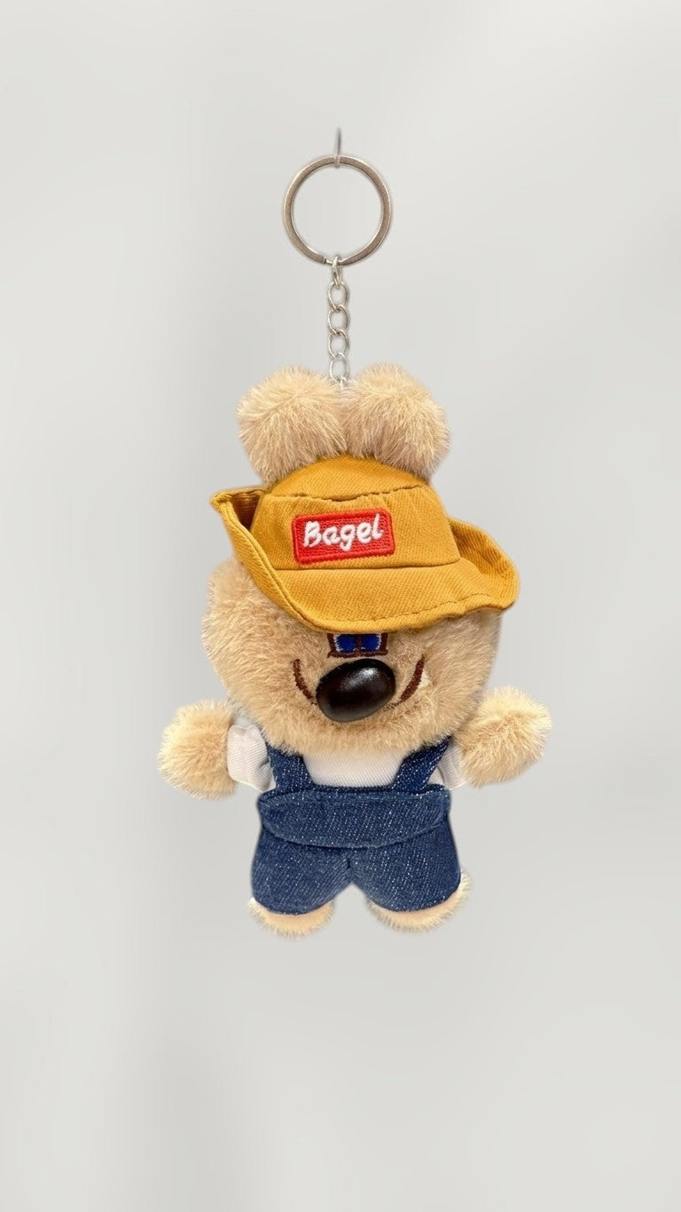 Tagerelsa3ada plush dog keychain with yellow hat and denim overalls, wearing a white shirt.
