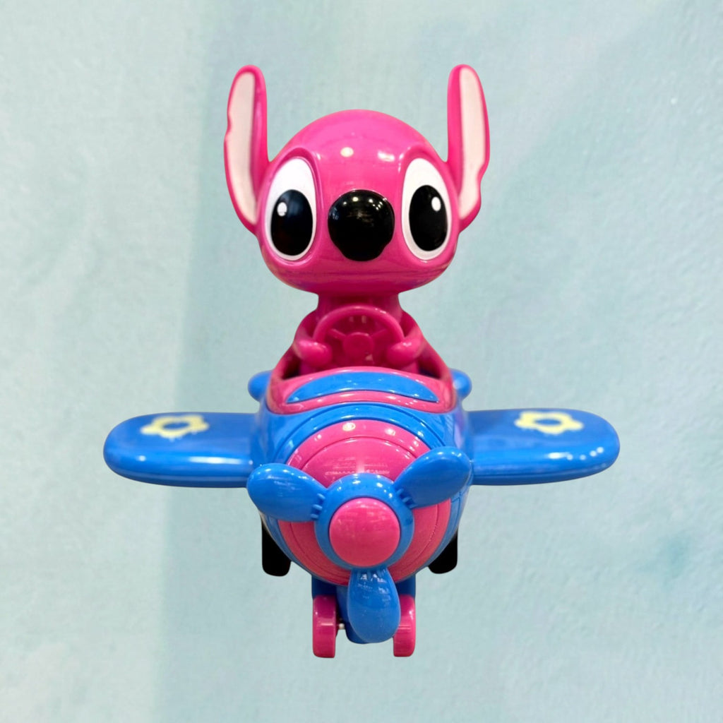Tagerelsa3ada Stitch character toy driving a pink and blue airplane with spinning propeller and flower details.
