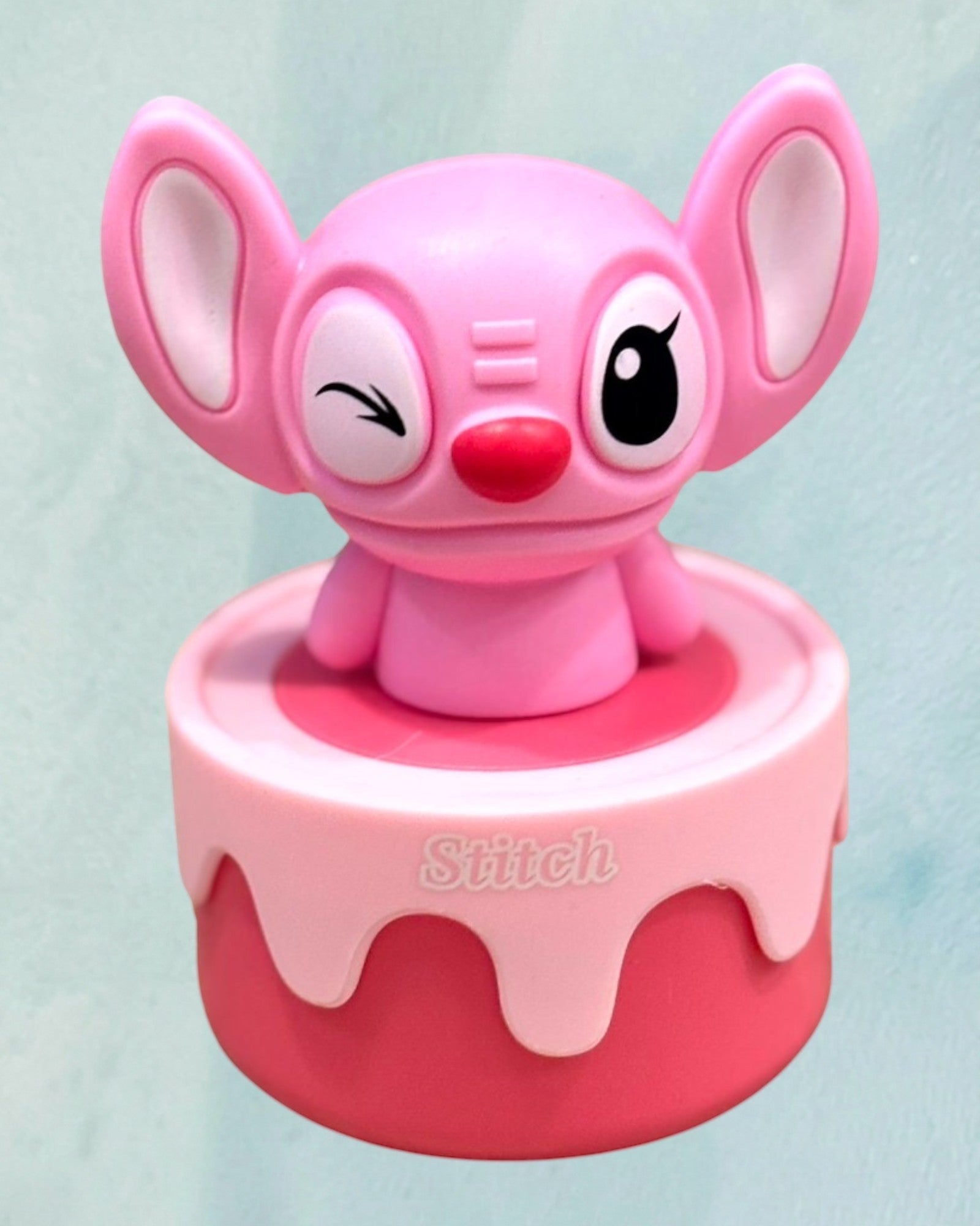 Tagerelsa3ada pink Stitch character figurine winking, with a pink and red base.