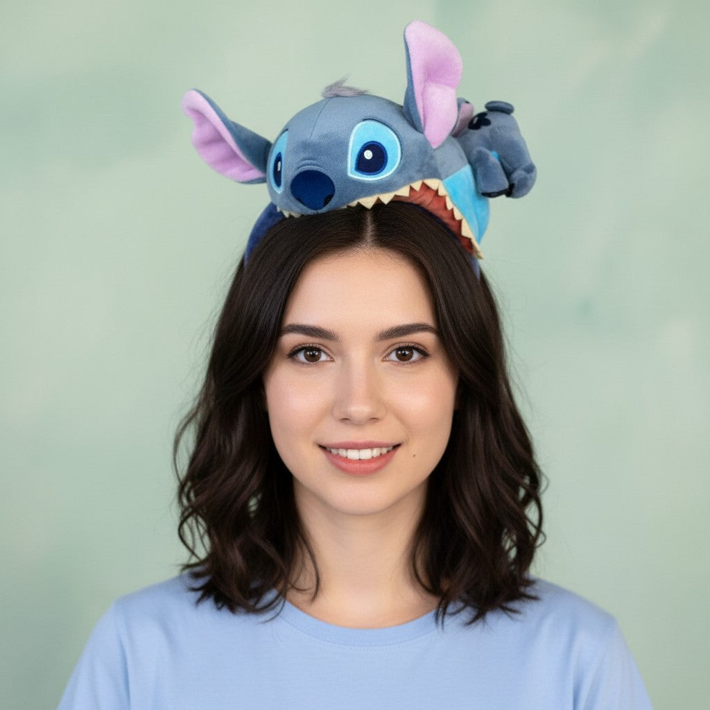 Tagerelsa3ada Disney Stitch plush headband with large blue eyes, pink inner ears, and open mouth with teeth.