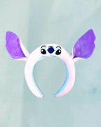Tagerelsa3ada white plush headband with large purple Stitch ears and embroidered face details.